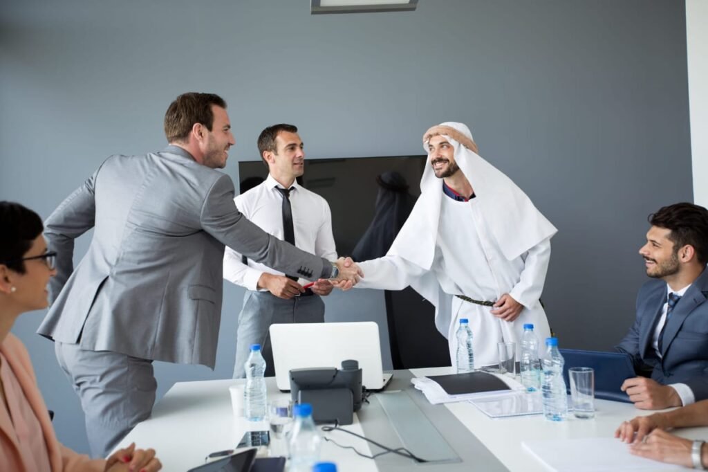 Entrepreneur explaining gratuity tool interface to a diverse team including an Arab and South Asian employee in modern office