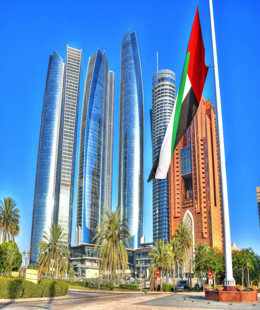 UAE flag waving in front of Abu Dhabi skyline building representing labour law benefits.